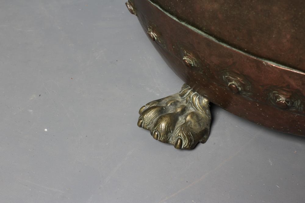 A COPPER LOG BIN, c.1900, of circular form with flared rim and riveted banding, on brass lion paw Image