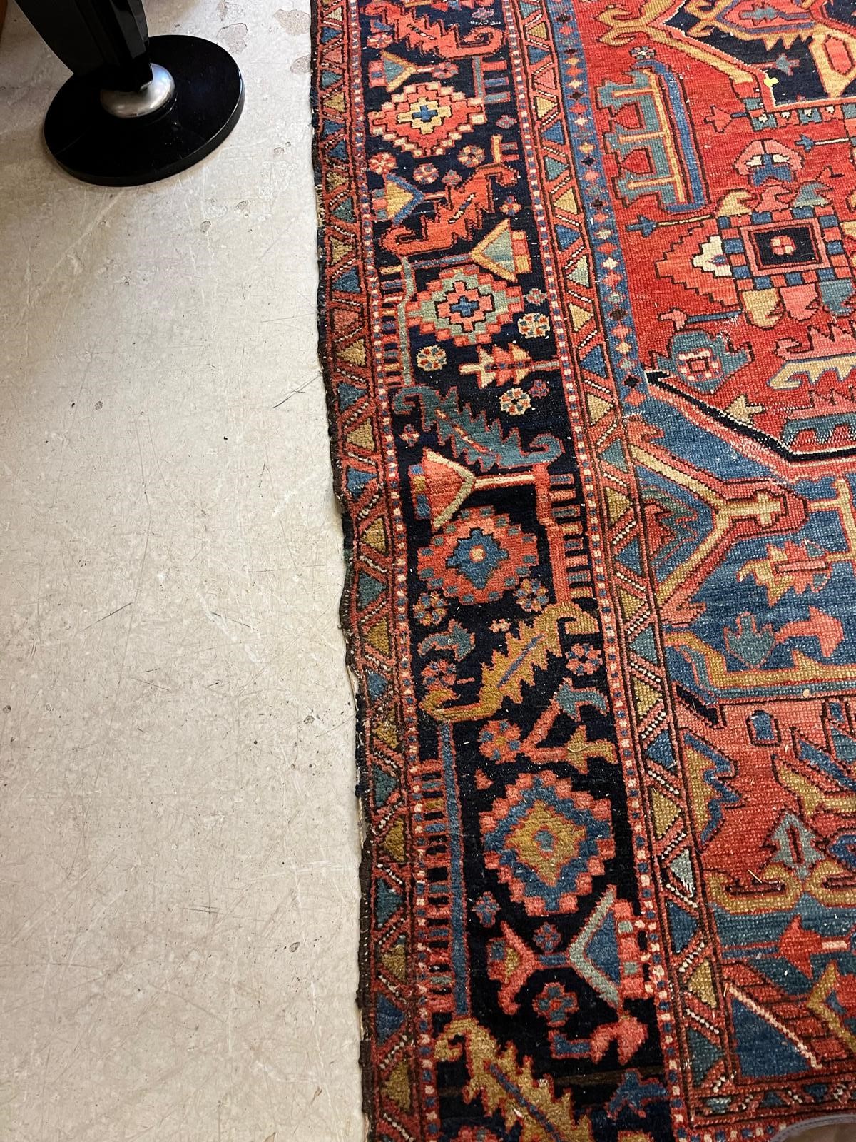 AN HERIZ CARPET, early 20th century, the madder field with large indigo gul and sky blue spandrels, Image