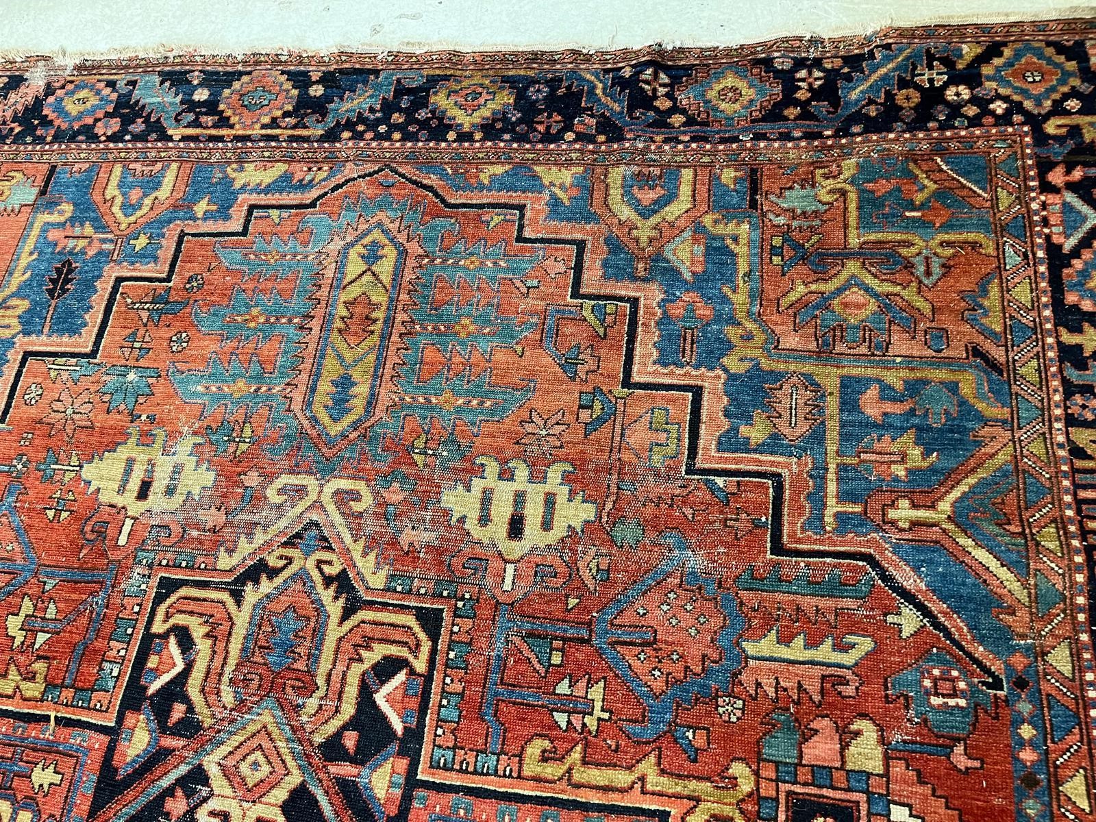 AN HERIZ CARPET, early 20th century, the madder field with large indigo gul and sky blue spandrels, Image