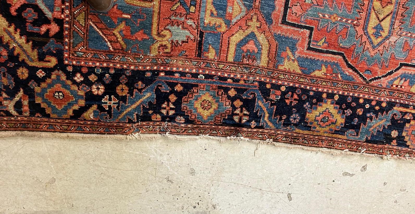AN HERIZ CARPET, early 20th century, the madder field with large indigo gul and sky blue spandrels, Image