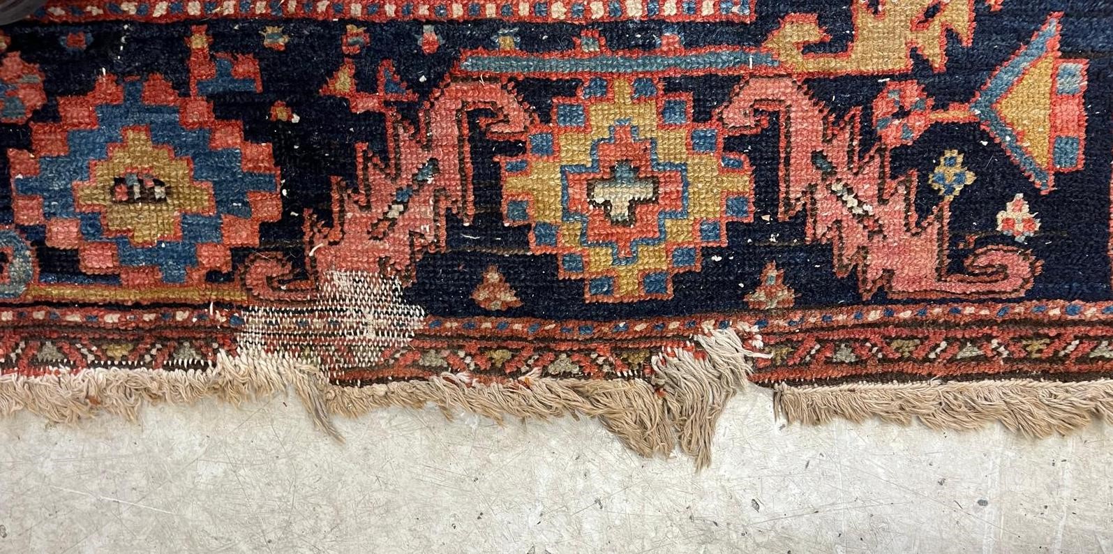 AN HERIZ CARPET, early 20th century, the madder field with large indigo gul and sky blue spandrels, Image