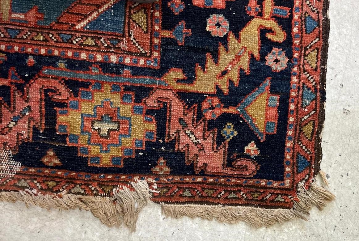 AN HERIZ CARPET, early 20th century, the madder field with large indigo gul and sky blue spandrels, Image