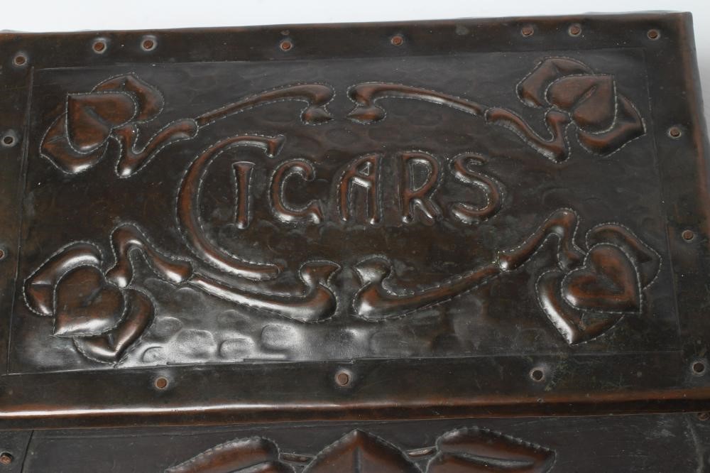 A CORNISH ARTS AND CRAFTS COPPER CIGAR BOX of sarcophagus form with rivet banding and repoussé with Image