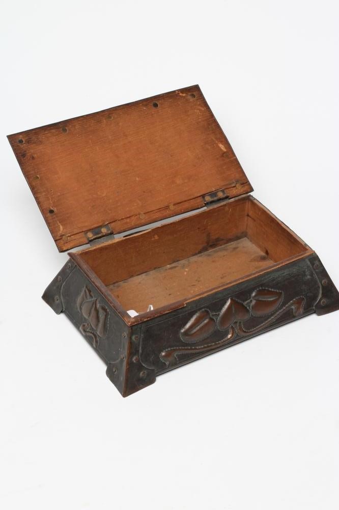 A CORNISH ARTS AND CRAFTS COPPER CIGAR BOX of sarcophagus form with rivet banding and repoussé with Image