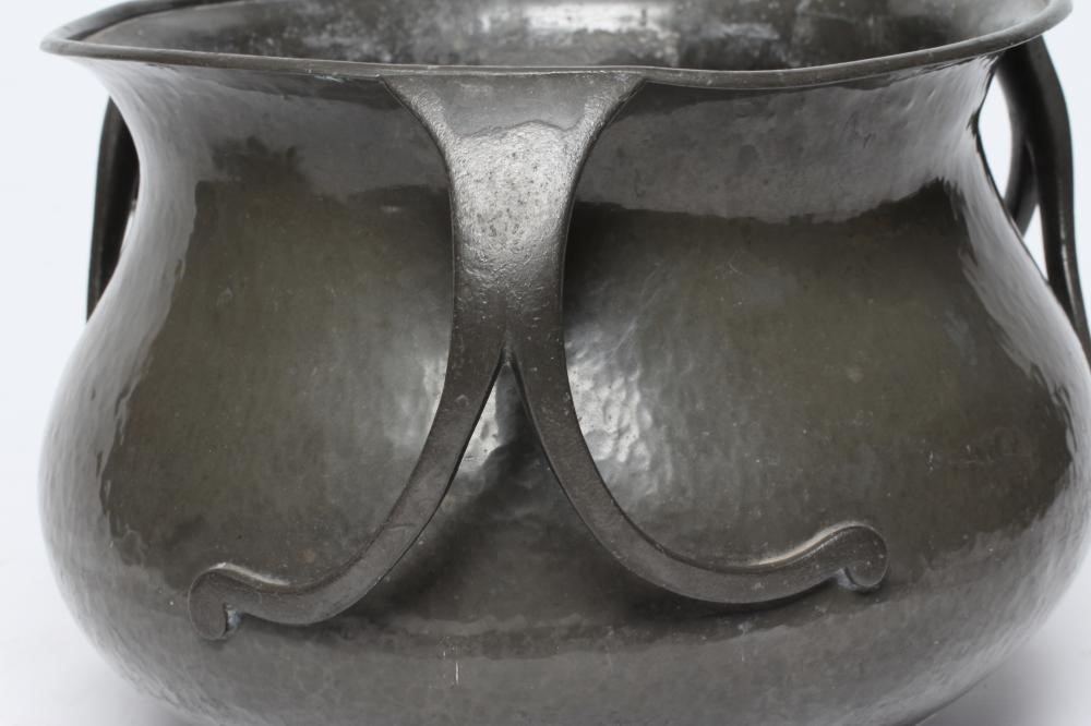 A LIBERTY AND CO. PEWTER JARDINIERE of planished baluster form with everted rim and three bifurcated Image