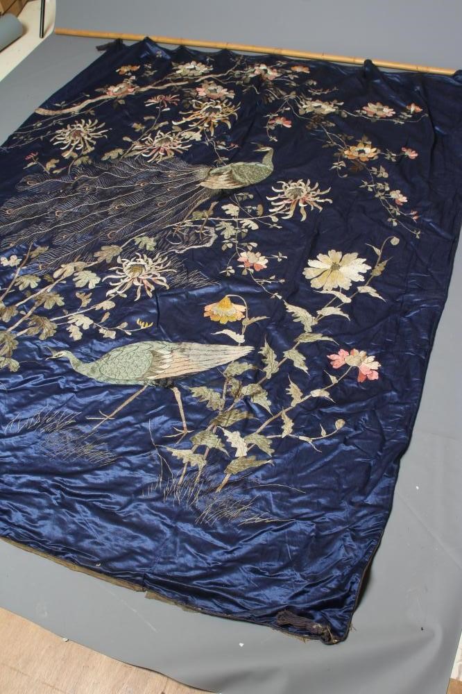 A LARGE CHINESE BLUE SILK PANEL embroidered in coloured silks with a pair of peacocks amidst Image