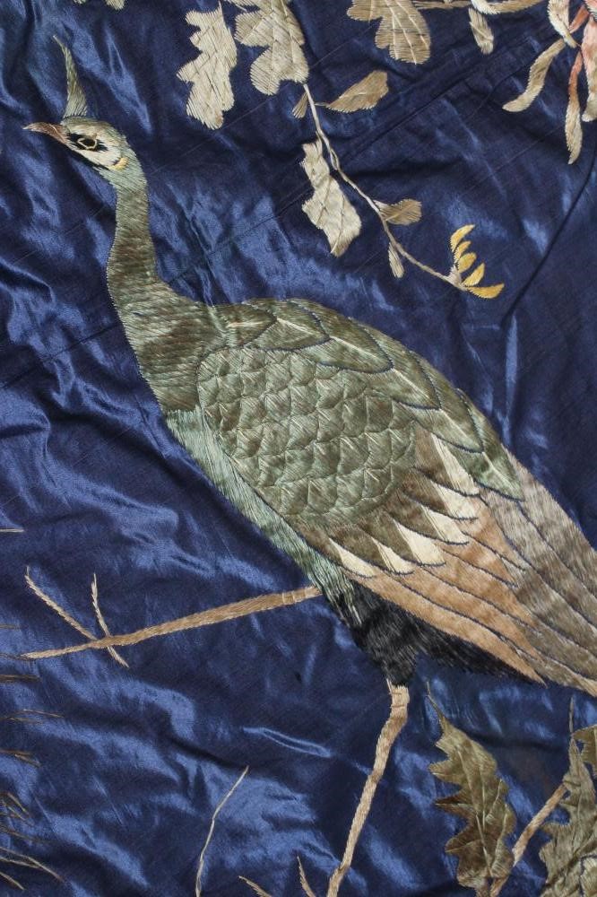 A LARGE CHINESE BLUE SILK PANEL embroidered in coloured silks with a pair of peacocks amidst Image