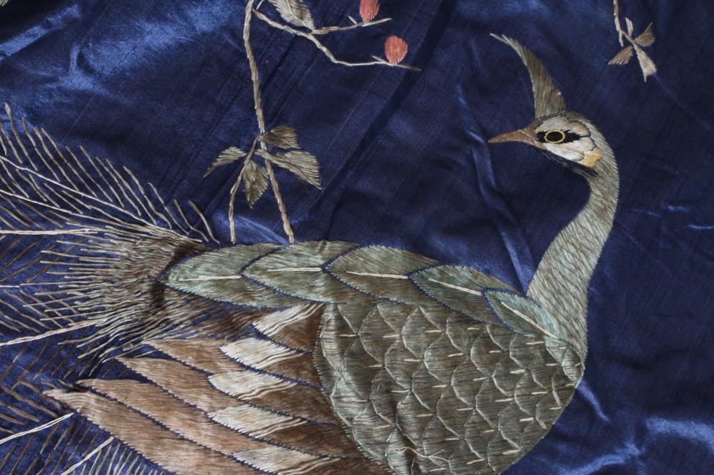 A LARGE CHINESE BLUE SILK PANEL embroidered in coloured silks with a pair of peacocks amidst Image