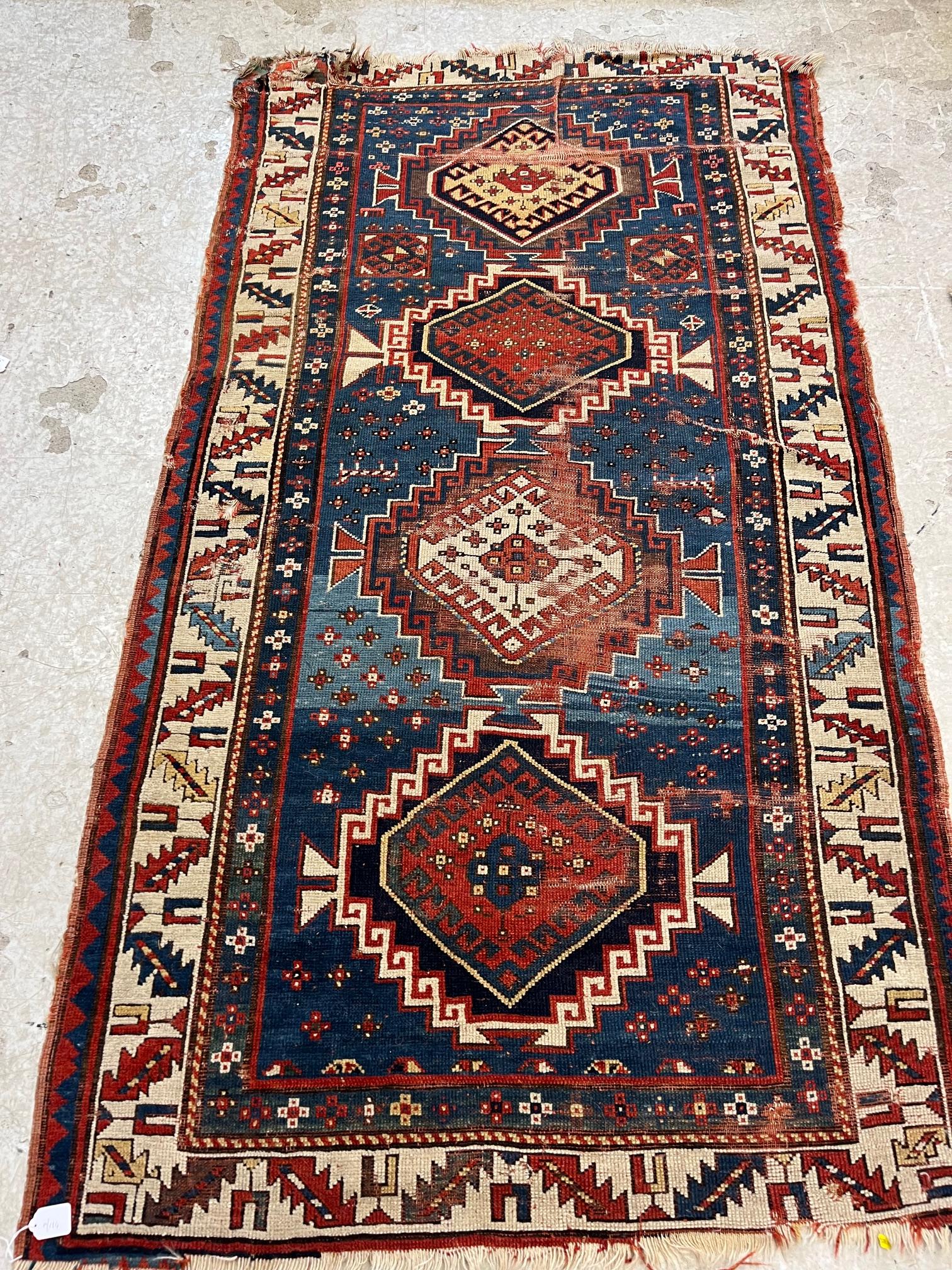 A KAZAK TRIBAL RUG, early 20th century, the indigo field with four linked guls in shades of blue, Image
