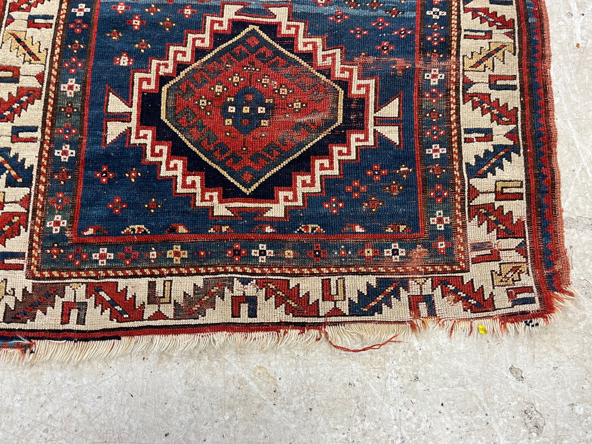 A KAZAK TRIBAL RUG, early 20th century, the indigo field with four linked guls in shades of blue, Image