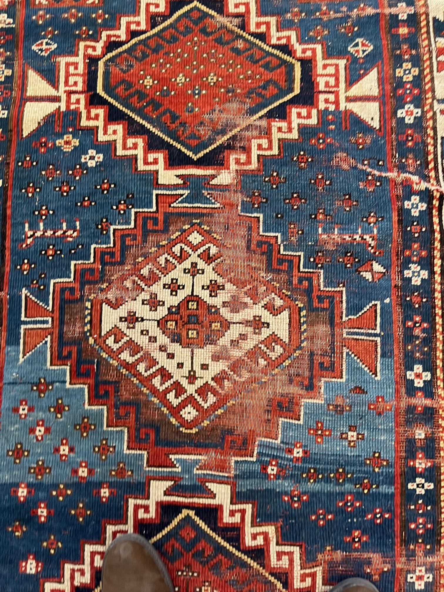 A KAZAK TRIBAL RUG, early 20th century, the indigo field with four linked guls in shades of blue, Image