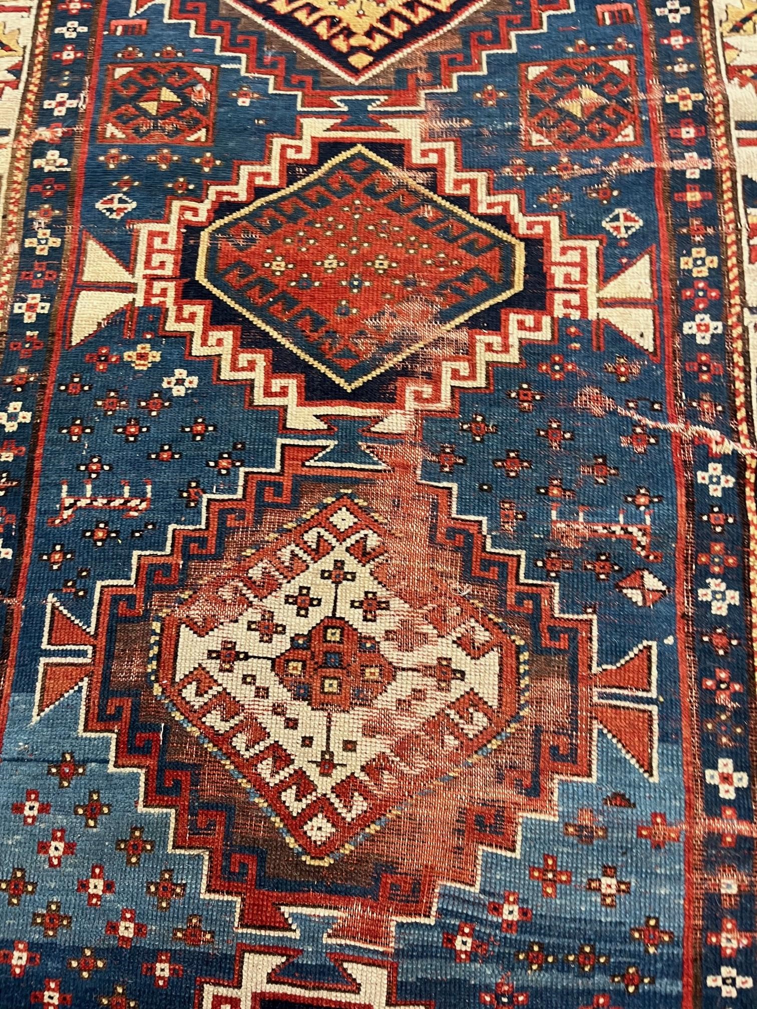 A KAZAK TRIBAL RUG, early 20th century, the indigo field with four linked guls in shades of blue, Image