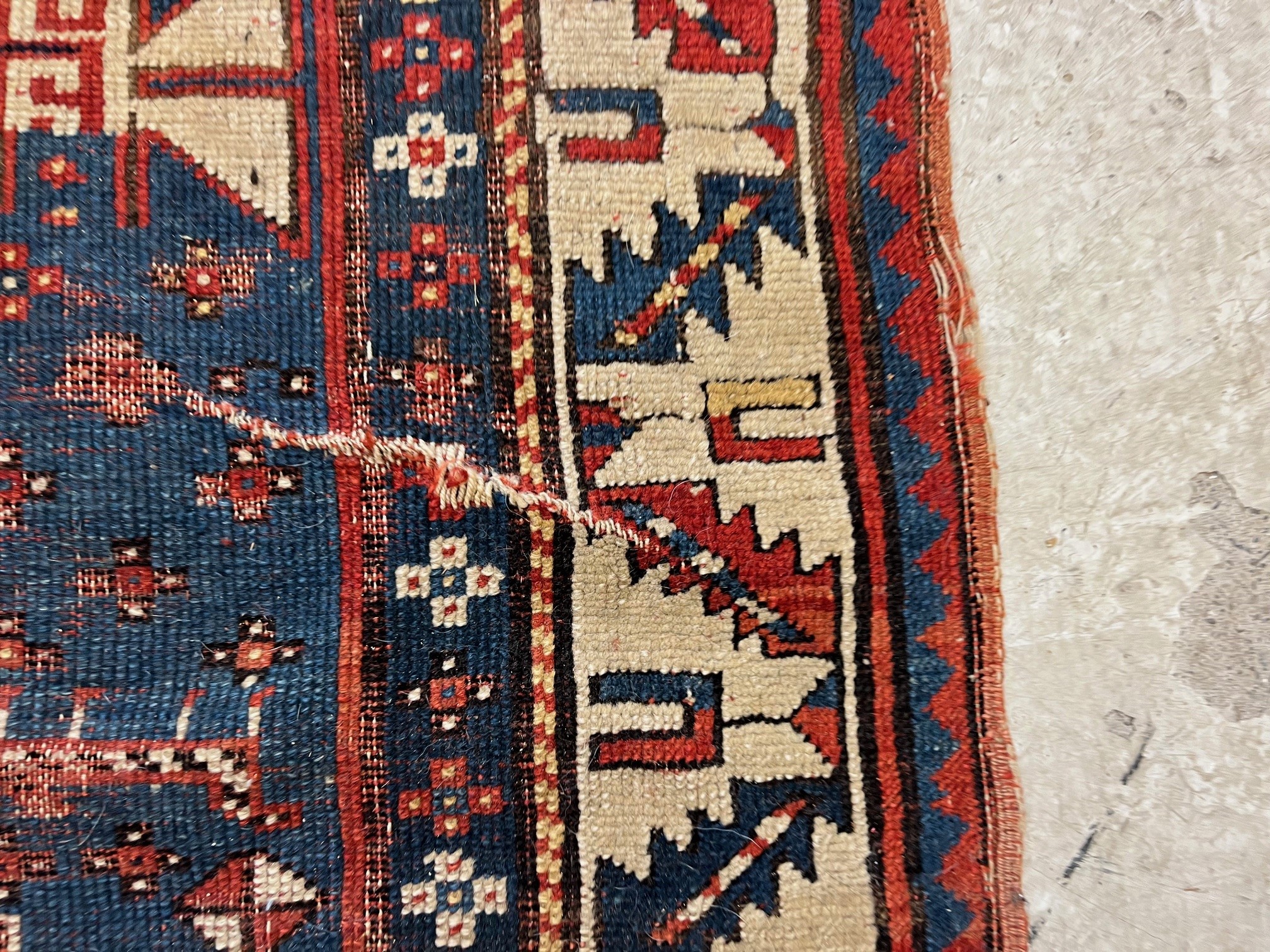 A KAZAK TRIBAL RUG, early 20th century, the indigo field with four linked guls in shades of blue, Image