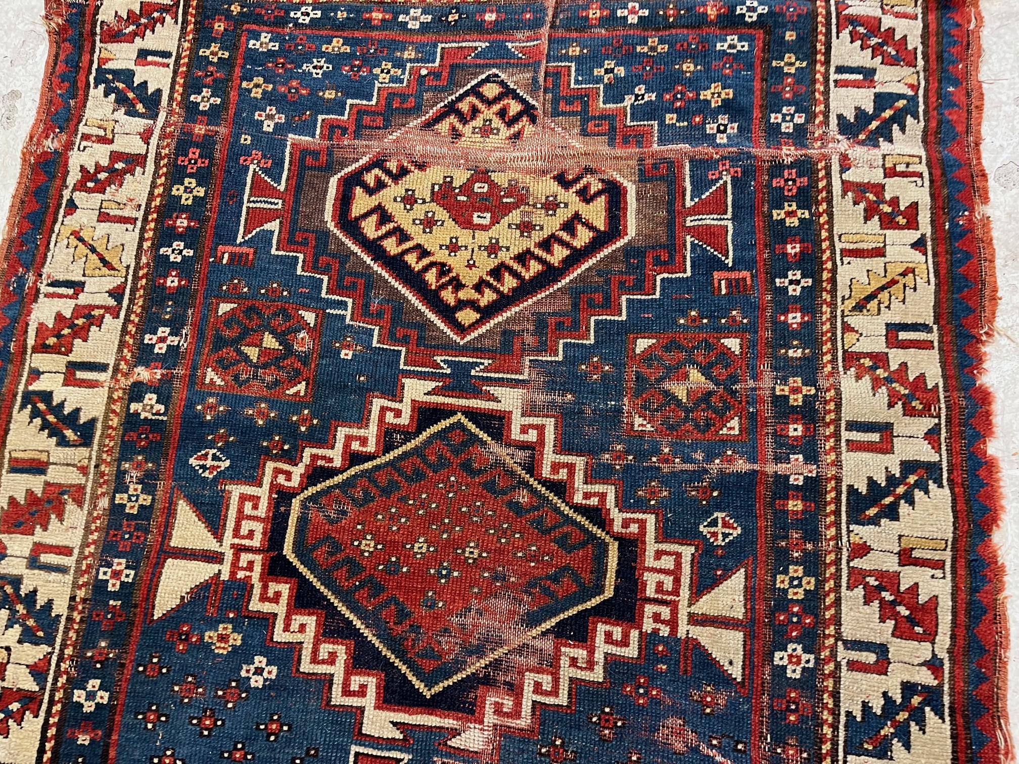 A KAZAK TRIBAL RUG, early 20th century, the indigo field with four linked guls in shades of blue, Image