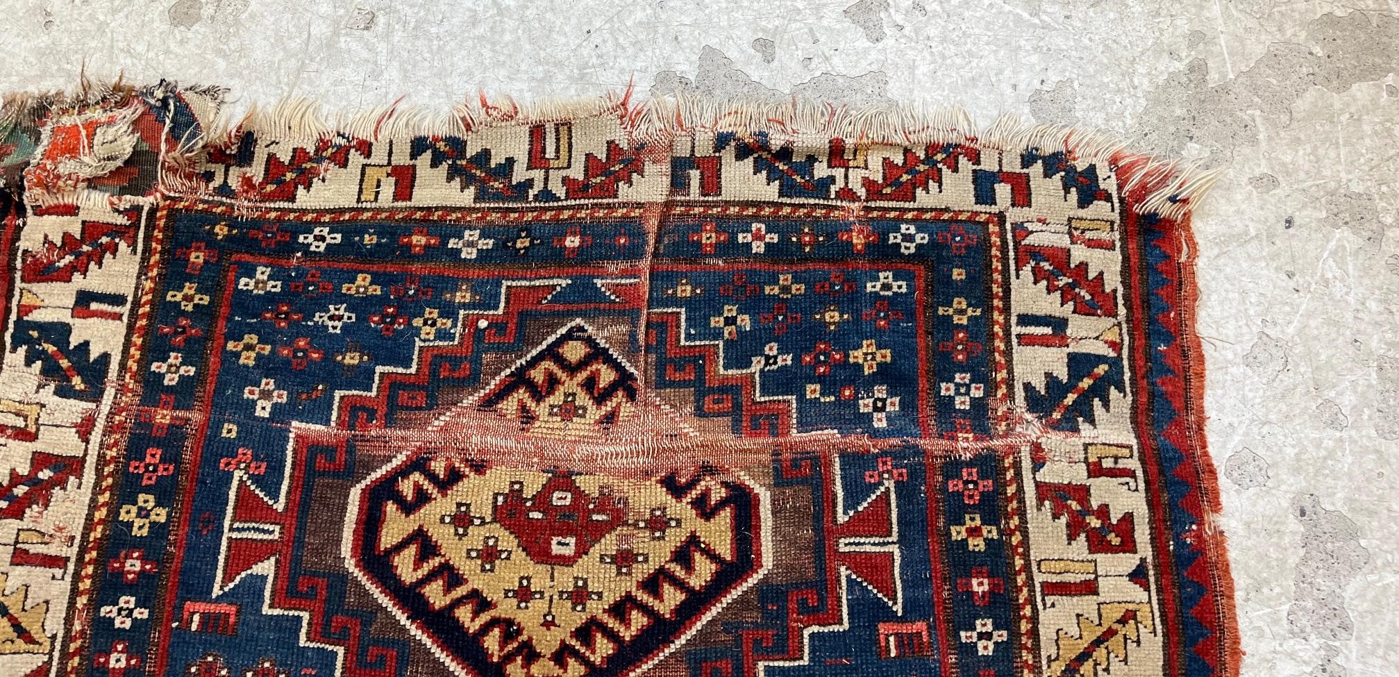 A KAZAK TRIBAL RUG, early 20th century, the indigo field with four linked guls in shades of blue, Image