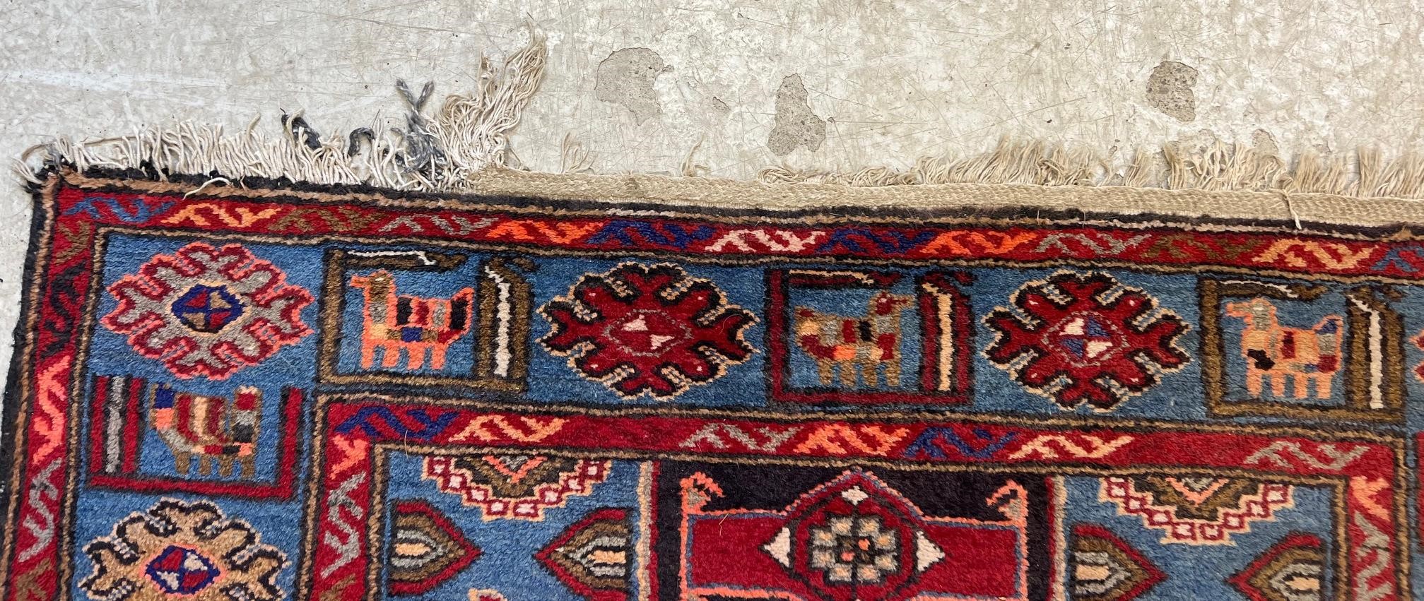 A PERSIAN STYLE WOOL RUG, modern, the black field with large claret red gul and sky blue spandrels, Image