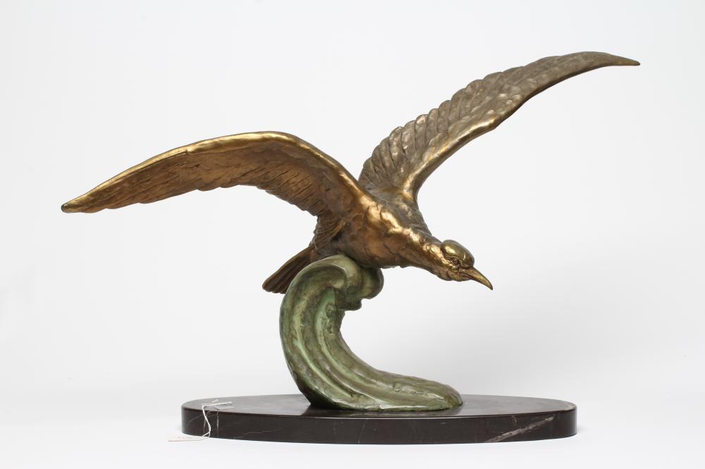 AN ART DECO GILT AND PATINATED METAL SEA BIRD modelled with outstretched wings on the crest of a Image