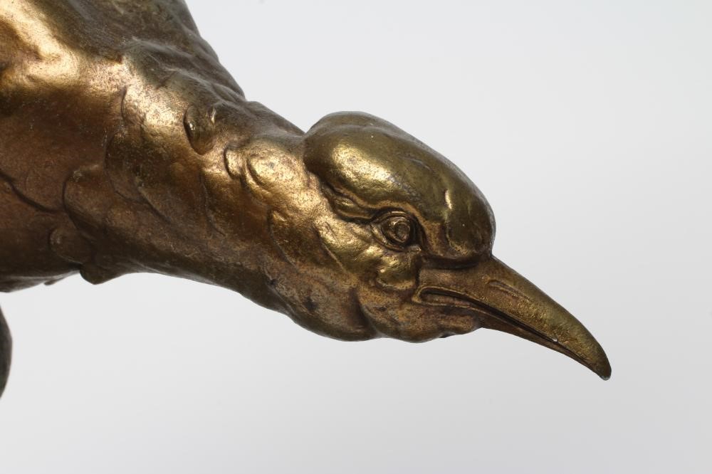AN ART DECO GILT AND PATINATED METAL SEA BIRD modelled with outstretched wings on the crest of a Image
