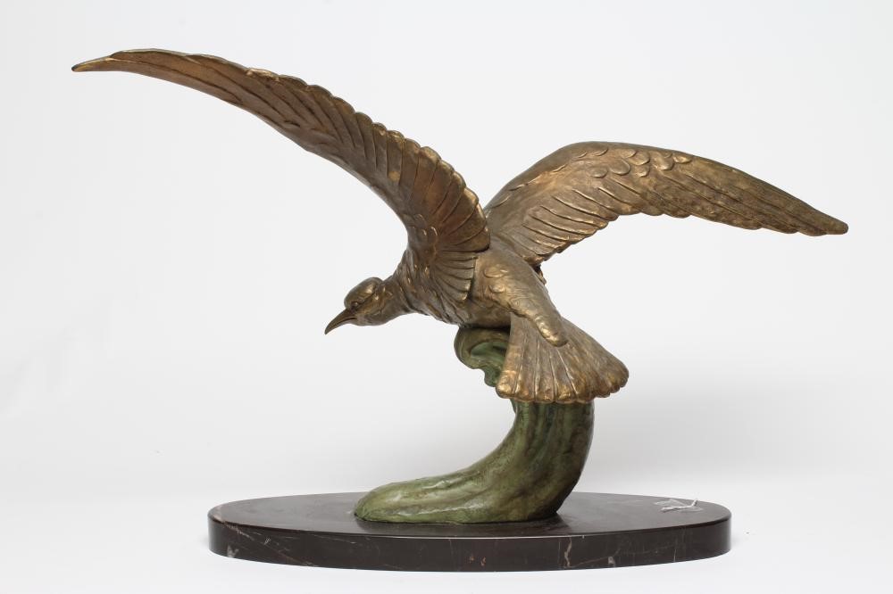 AN ART DECO GILT AND PATINATED METAL SEA BIRD modelled with outstretched wings on the crest of a Image