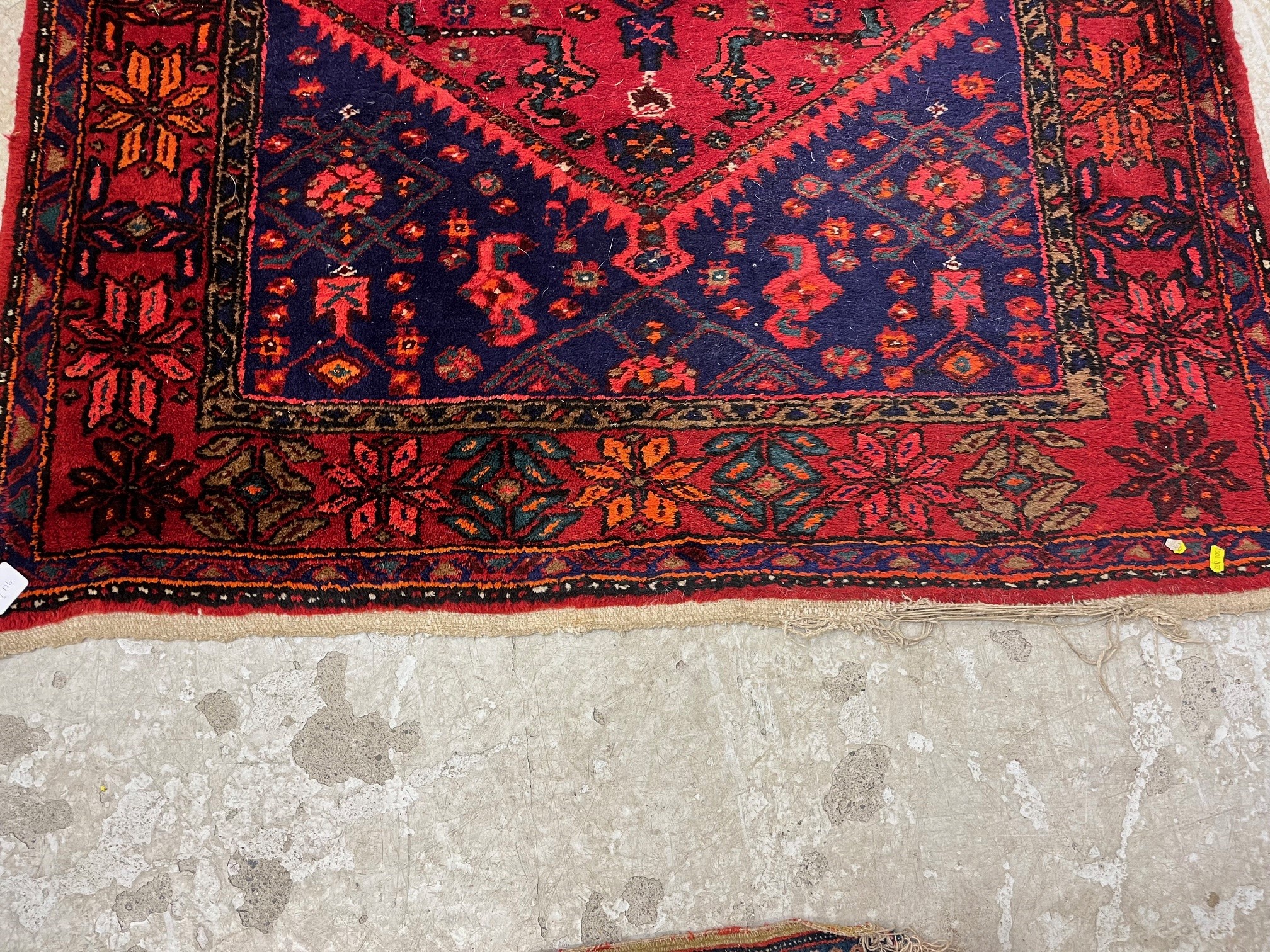 A PERSIAN STYLE WOOL RUG, modern, the burgundy floral field with indigo gul and spandrels, within a Image