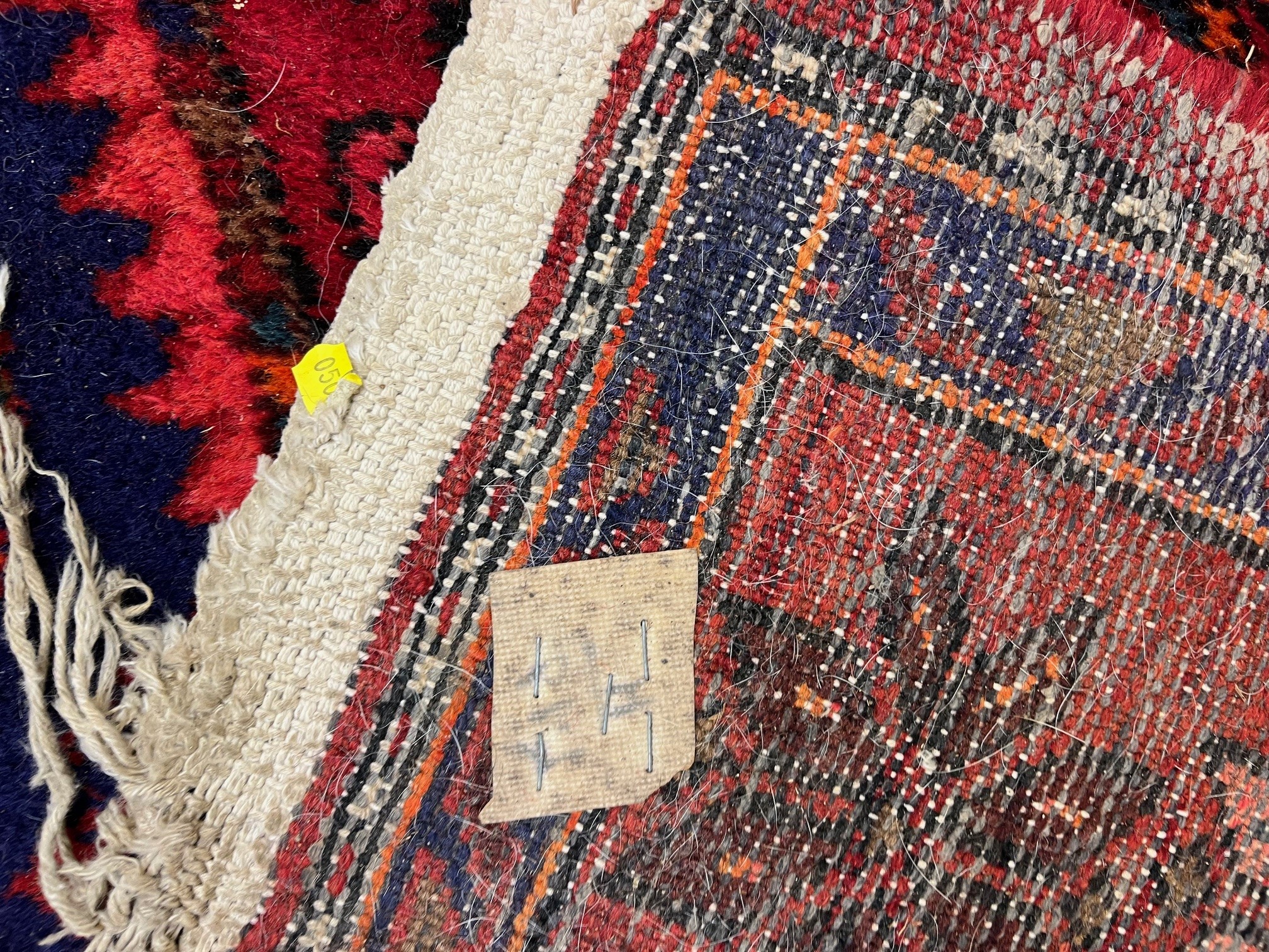 A PERSIAN STYLE WOOL RUG, modern, the burgundy floral field with indigo gul and spandrels, within a Image