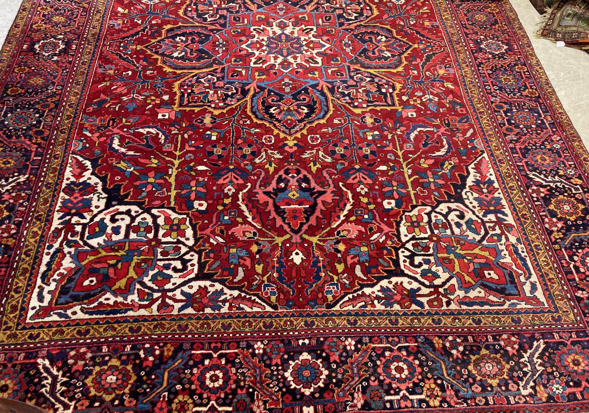 AN HERIZ CARPET, mid 20th century, the terracotta field with central flowerhead medallion bordered Image