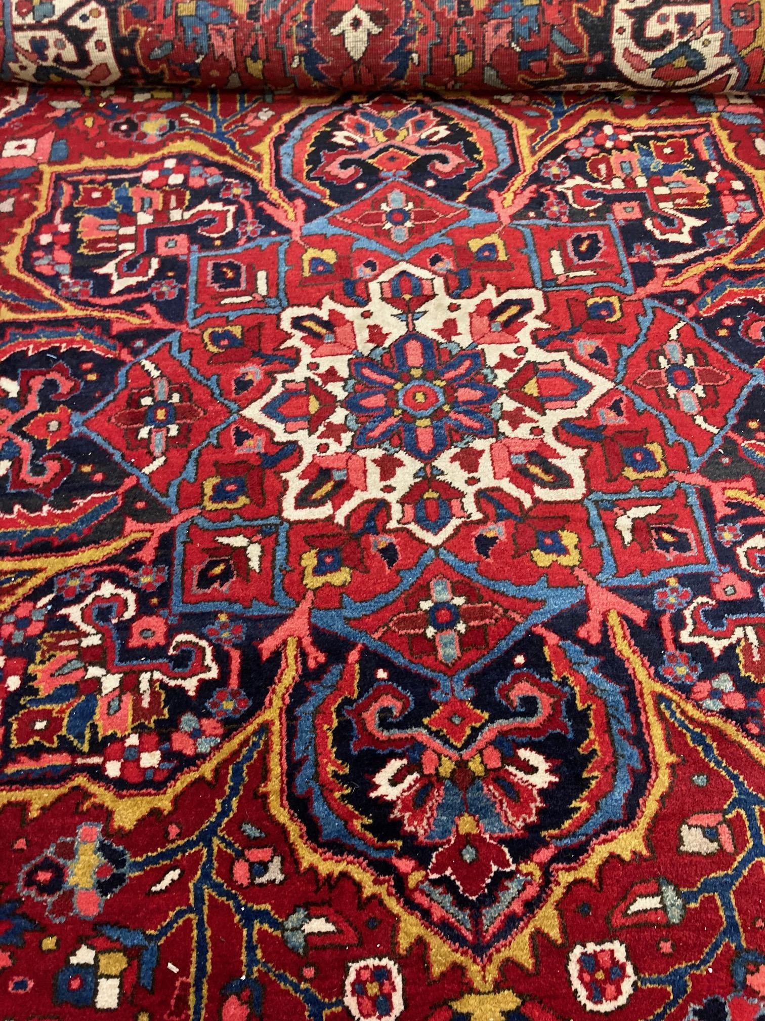 AN HERIZ CARPET, mid 20th century, the terracotta field with central flowerhead medallion bordered Image