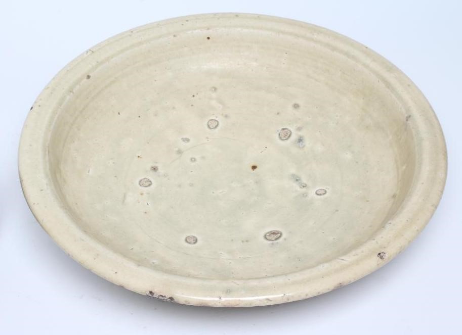 A CHINESE CELADON GLAZED STONEWARE SHALLOW BOWL of plain circular form Image