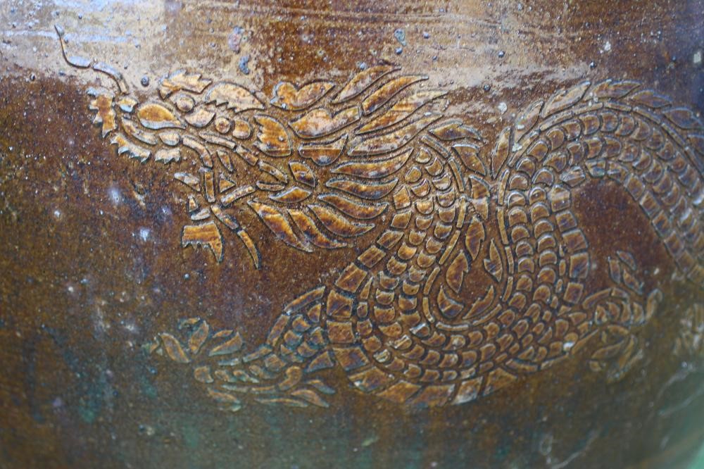 A VERY LARGE SALT GLAZED PLANT POT of tapering form incised with Chinese dragons, resting on a Image