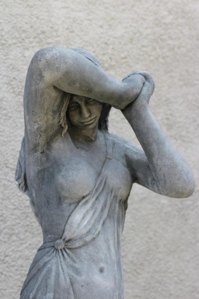 A CAST STONE FIGURE OF A NYMPH, raised on square wreath moulded plinth, 13 1/2" x 59 1/2" (Est. plus Image