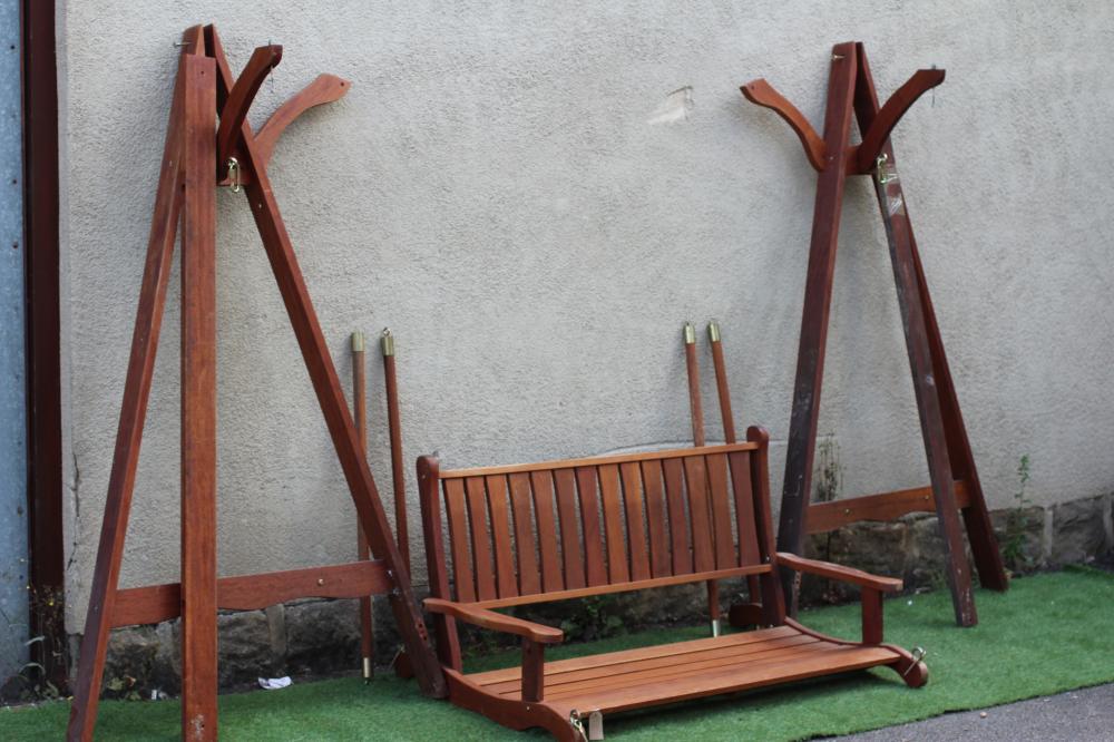 A SLATTED TEAK SWING GARDEN BENCH, modern, the mildly curved back with straight top rail, shaped Image