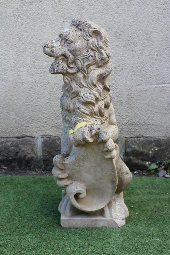 A CAST STONE HERALDIC LION SEJANT holding a shield, 12" x 38 1/2" (Est. plus 24% premium inc. VAT) Image