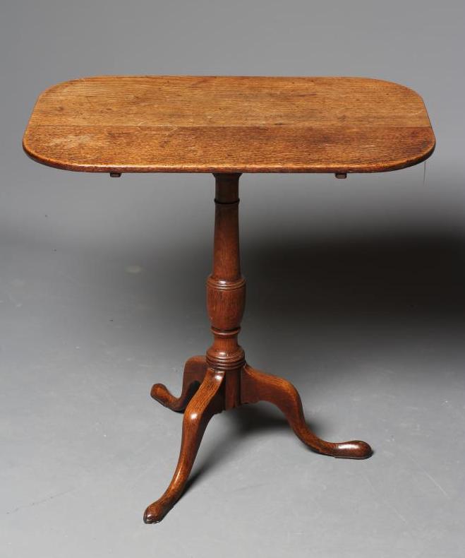 A GEORGIAN OAK TRIPOD TABLE, early 19th century, the rounded oblong tilt top on turned vase stem Image