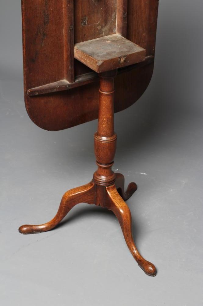 A GEORGIAN OAK TRIPOD TABLE, early 19th century, the rounded oblong tilt top on turned vase stem Image