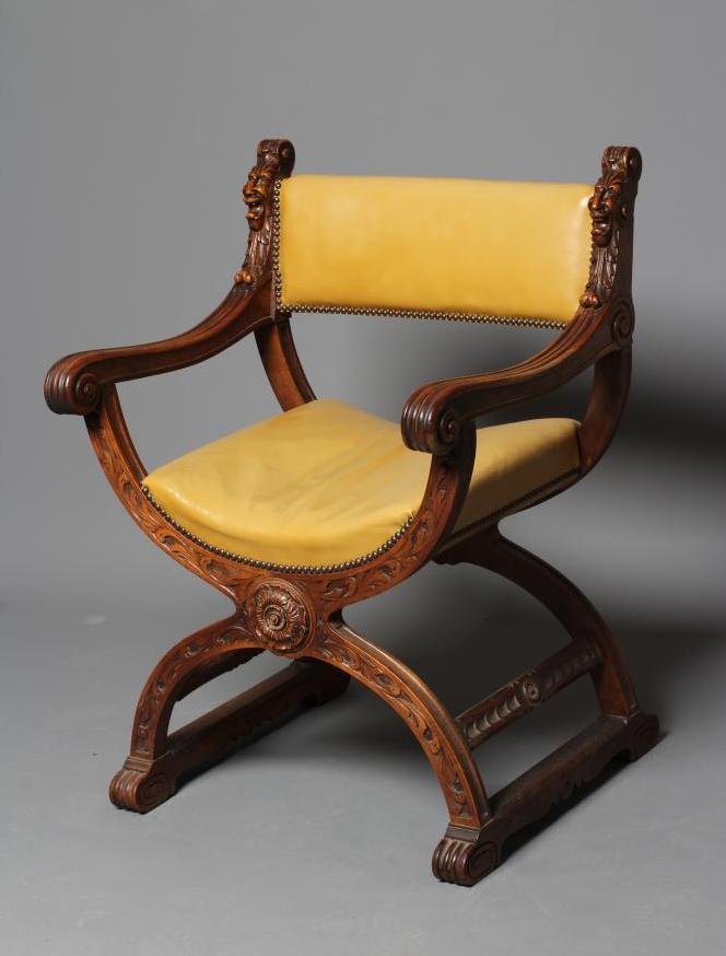 A CARVED WALNUT SAVONAROLA TYPE ARMCHAIR Image