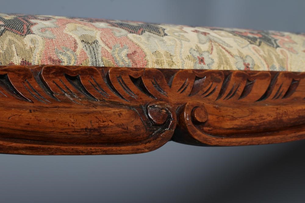 A VICTORIAN CARVED WALNUT FENDER STOOL of serpentine oblong form upholstered in a tapestry weave Image
