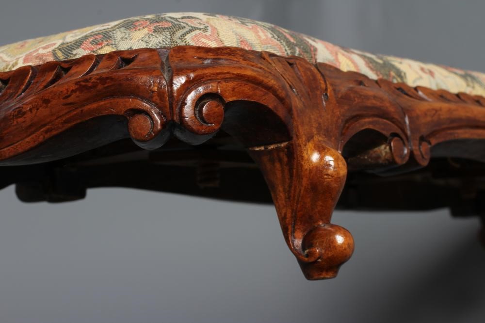 A VICTORIAN CARVED WALNUT FENDER STOOL of serpentine oblong form upholstered in a tapestry weave Image