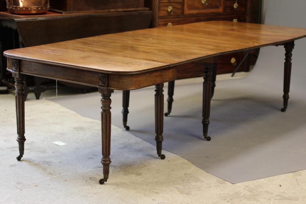 A REGENCY MAHOGANY FOLDING AND EXTENDING DINING TABLE in the manner of Gillow Image