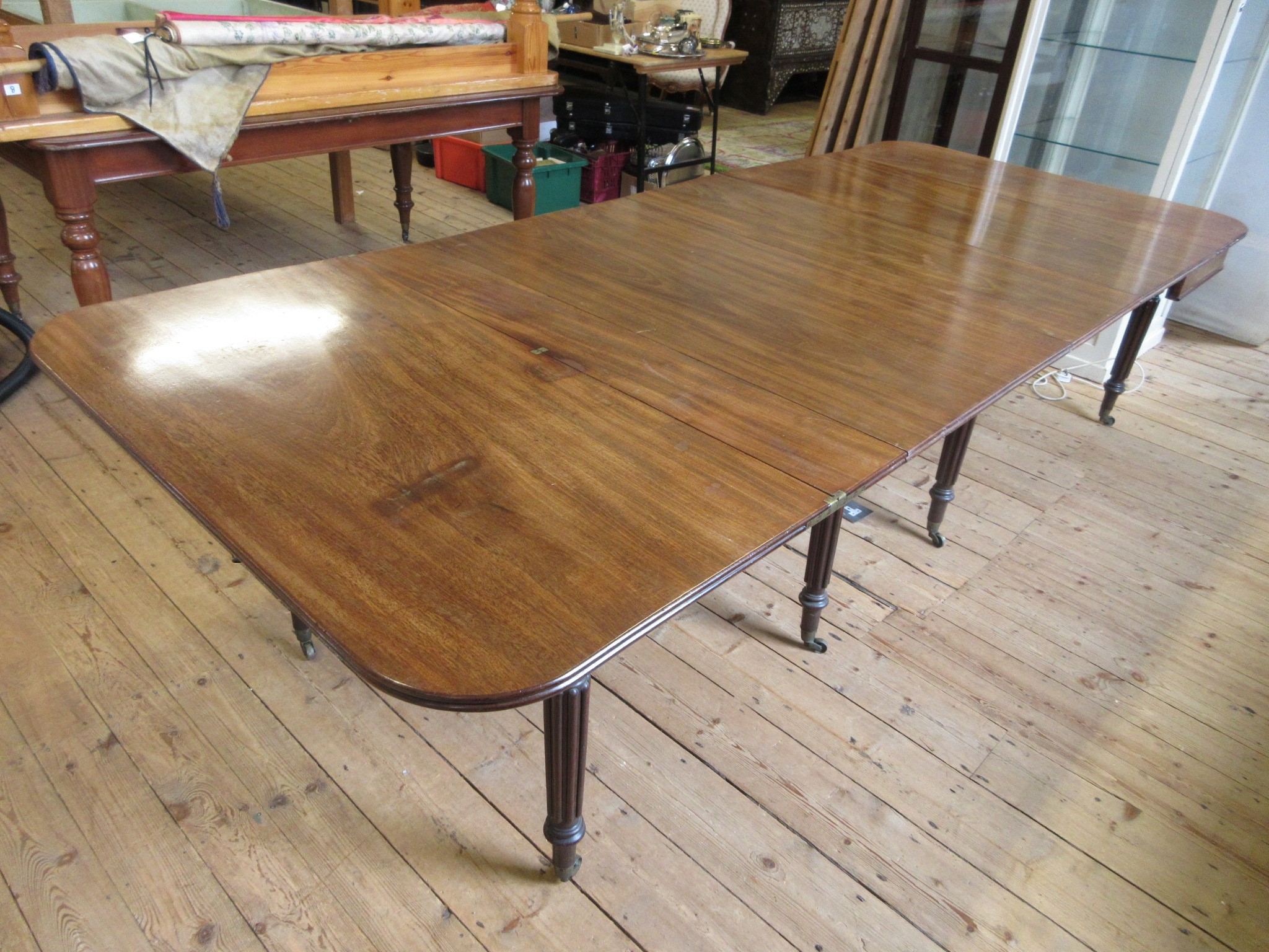 A REGENCY MAHOGANY FOLDING AND EXTENDING DINING TABLE in the manner of Gillow Image