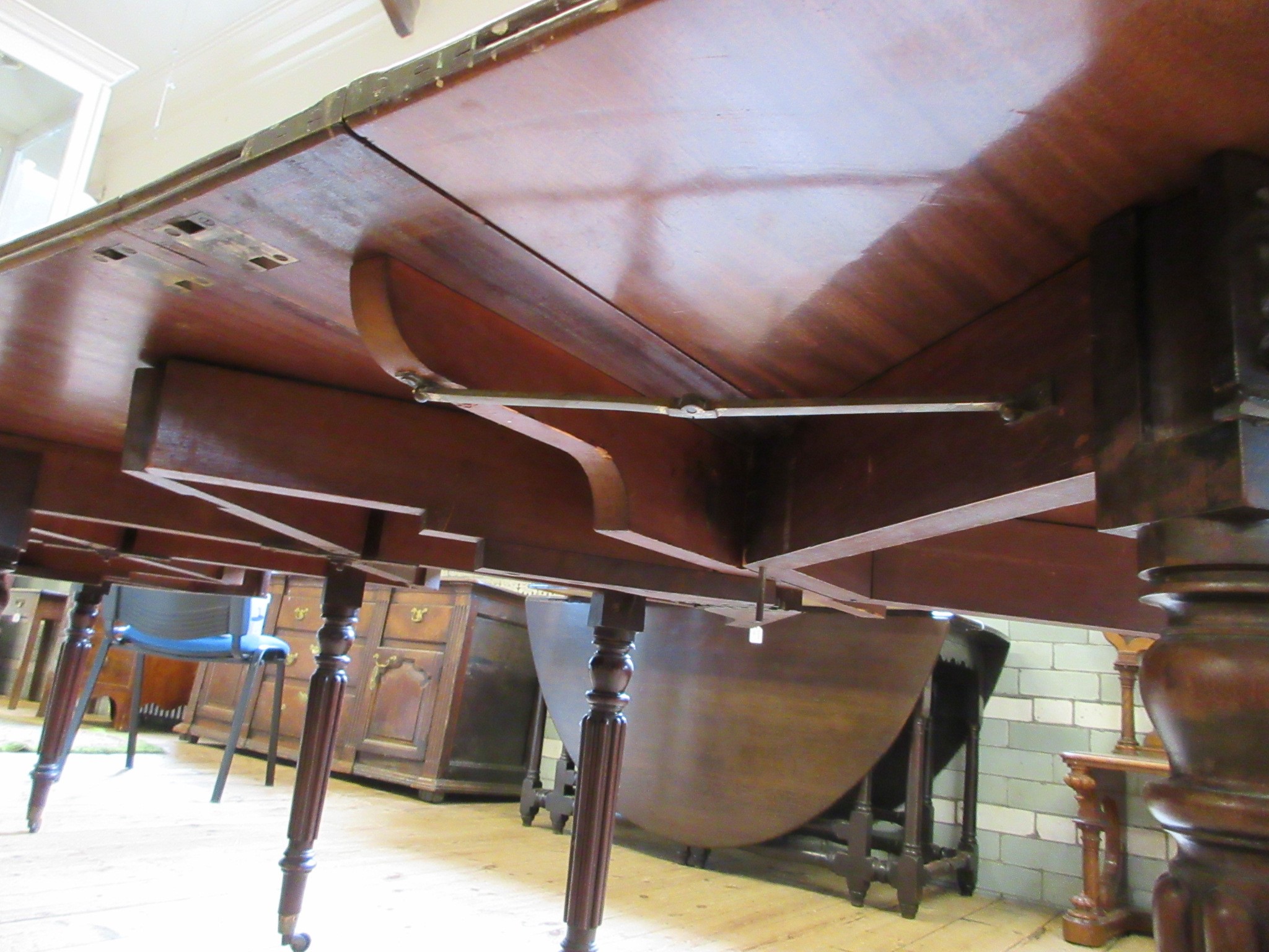 A REGENCY MAHOGANY FOLDING AND EXTENDING DINING TABLE in the manner of Gillow Image