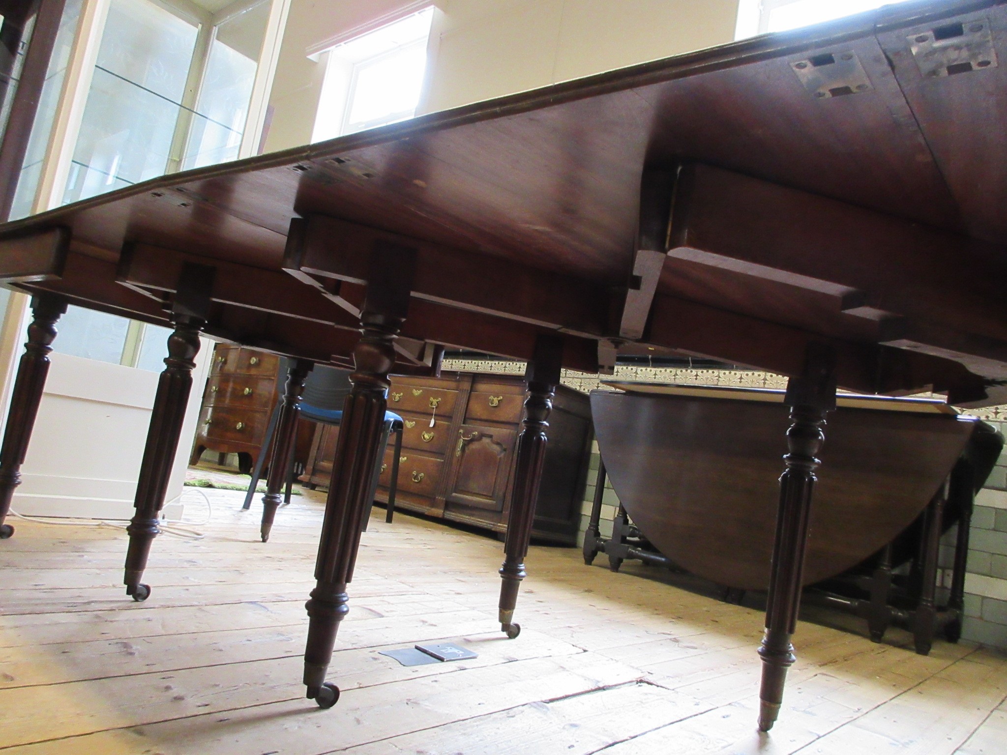 A REGENCY MAHOGANY FOLDING AND EXTENDING DINING TABLE in the manner of Gillow Image