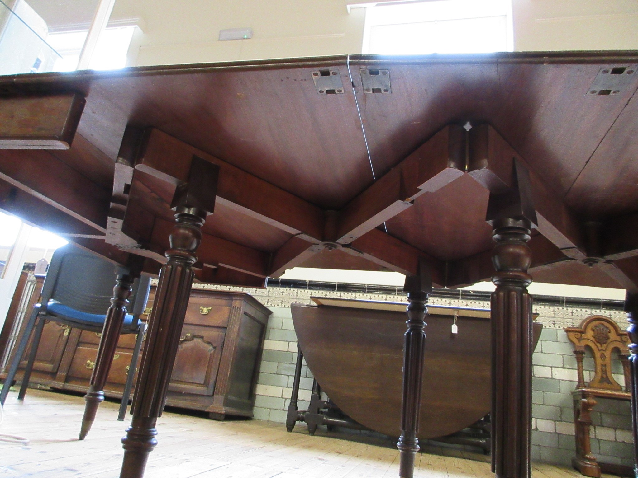 A REGENCY MAHOGANY FOLDING AND EXTENDING DINING TABLE in the manner of Gillow Image