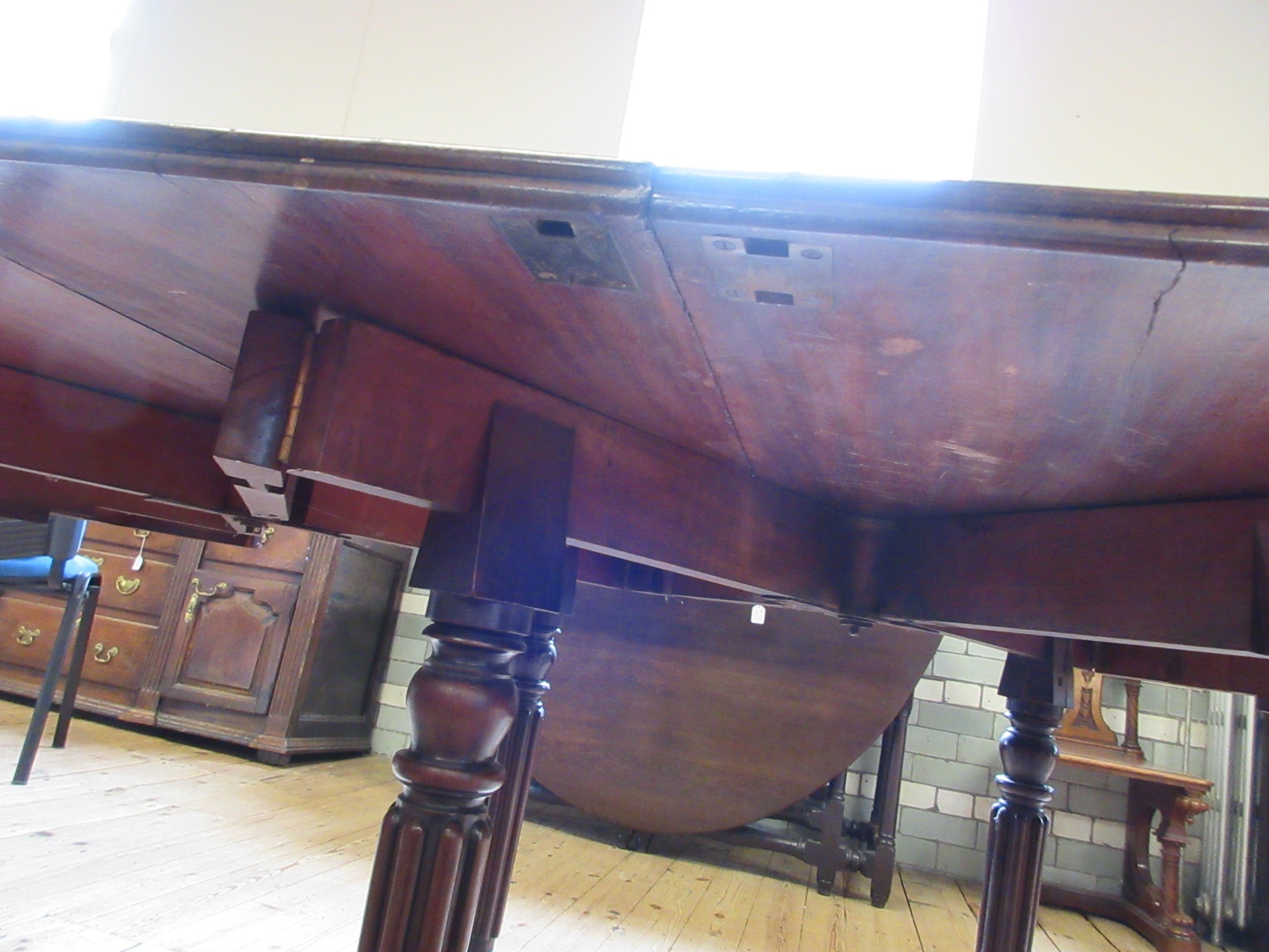 A REGENCY MAHOGANY FOLDING AND EXTENDING DINING TABLE in the manner of Gillow Image