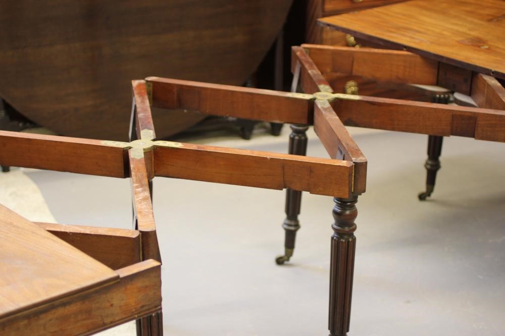 A REGENCY MAHOGANY FOLDING AND EXTENDING DINING TABLE in the manner of Gillow Image