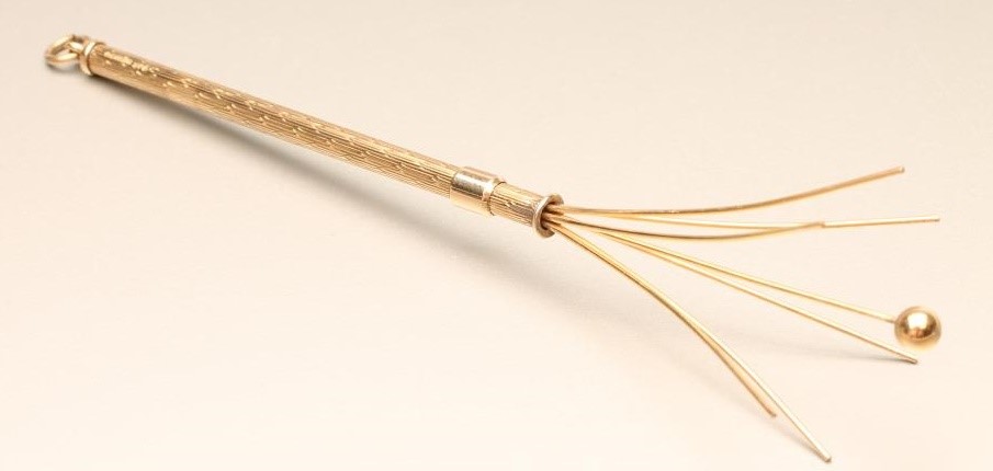 A 9CT GOLD PROPELLING SWIZZLE STICK of plain cylindrical form with engine turning and hanging loop Image