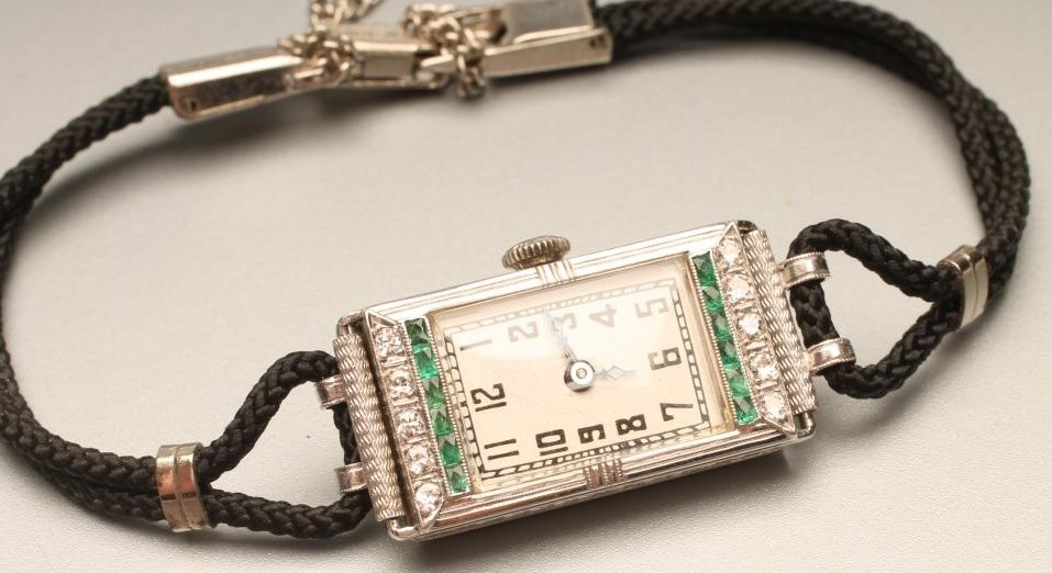 AN ART DECO DIAMOND AND EMERALD COCKTAIL WATCH Image