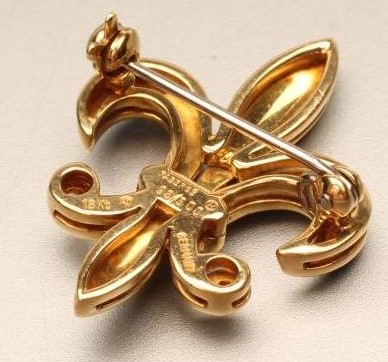 A "HOUSE OF FABERGE" 18KT GOLD AND DIAMOND FLEUR DE LYS BROOCH with blue enamelling Image