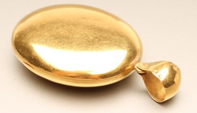 A VICTORIAN GOLD OVAL LOCKET applied with a monogram and enclosing two sepia portrait photographs Image