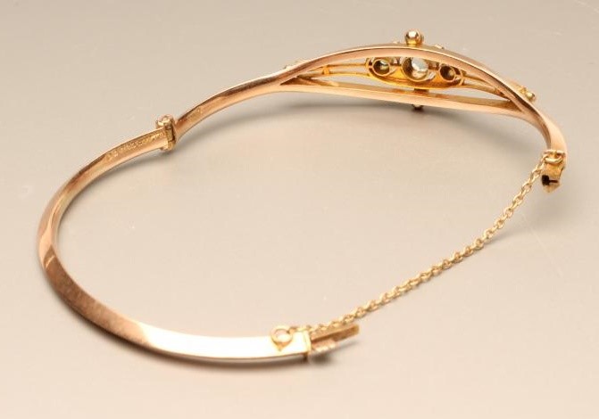 A 9CT GOLD STIFF HINGED BANGLE Image