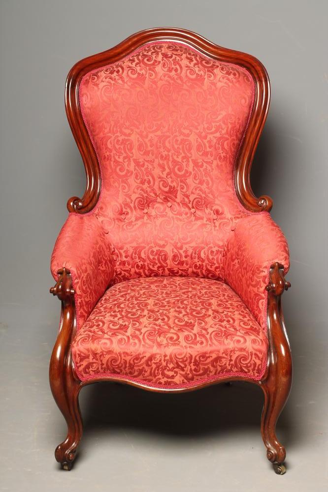 A VICTORIAN WALNUT FRAMED EASY CHAIR of spoonback form upholstered in red brocade Image